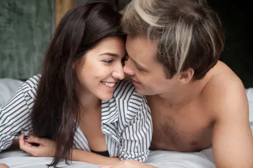 Intimate moment between woman and man lying in a bed togther.